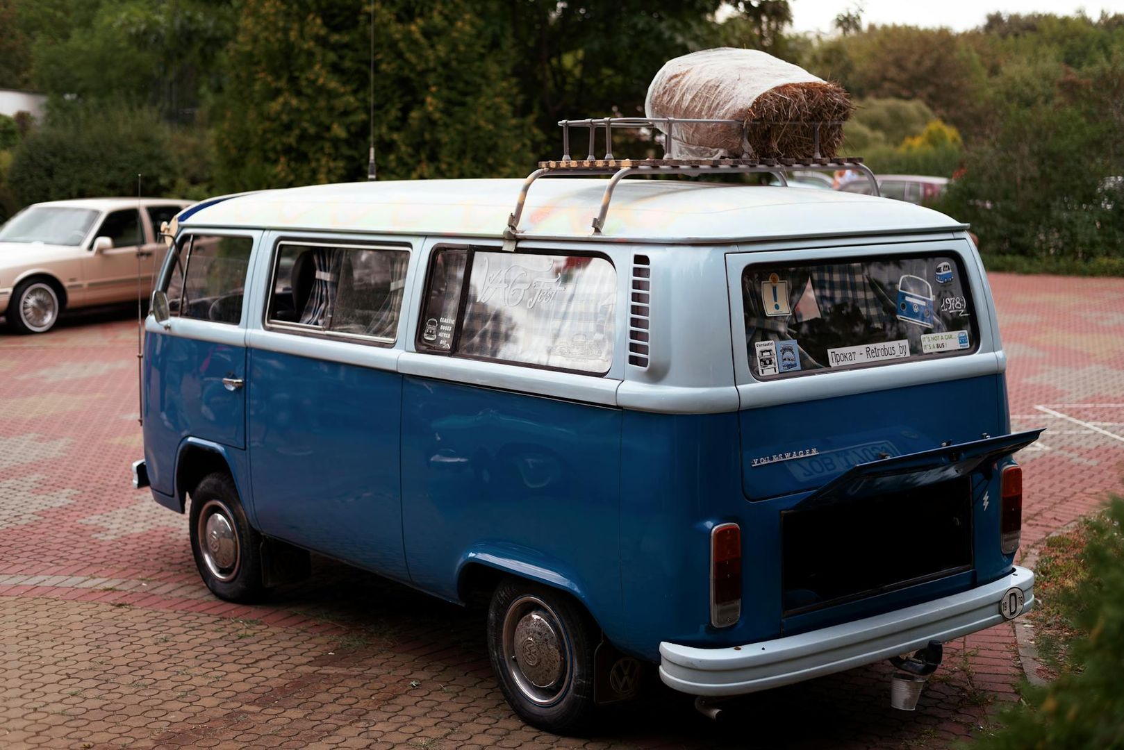 Klassisk blå og hvit Volkswagen varebil med takstativ og bagasje.