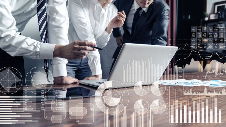 Forretningsfolk analyserer finansielle data på en bærbar datamaskin.